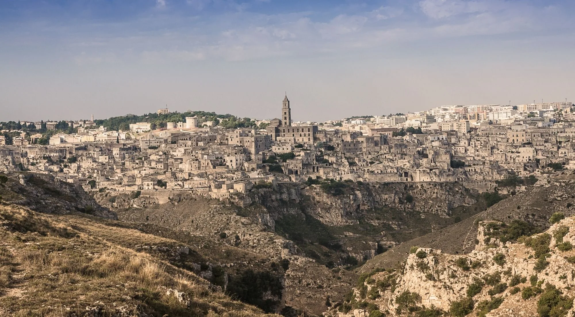 Matera's old town spread along the far rim of the Gravina gorge, seen from the plateau opposite