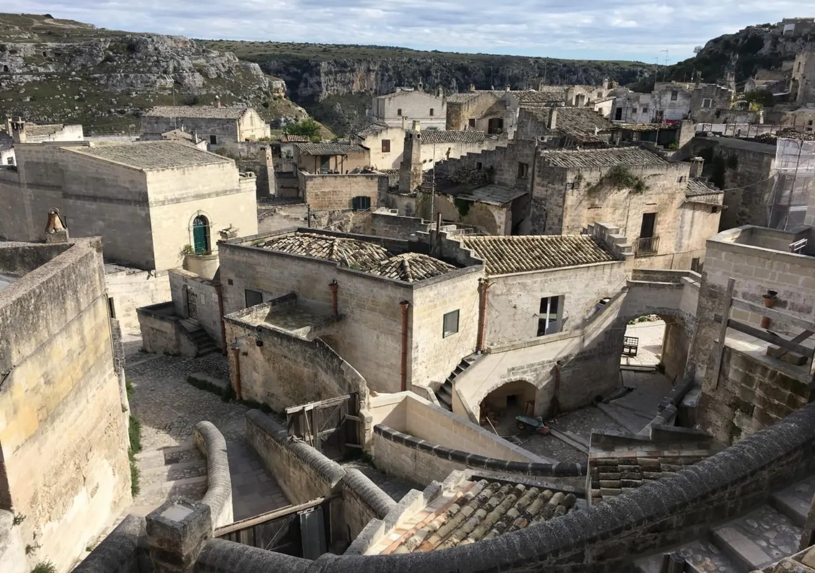 Looking down on stone houses, stairways and tiled roofs of the Sassi, with the Gravina gorge beyond.